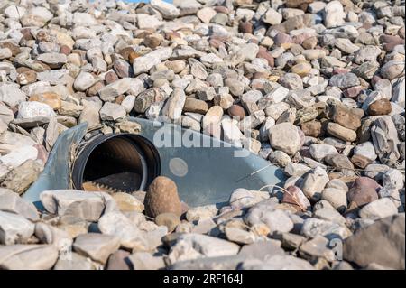 underground drainage storm drain with winged walls surrounded by rock for erosion control  Stock Photo