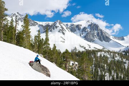Snowshoer trekking the McGee Pass Trail with a mountain backdrop Stock Photo