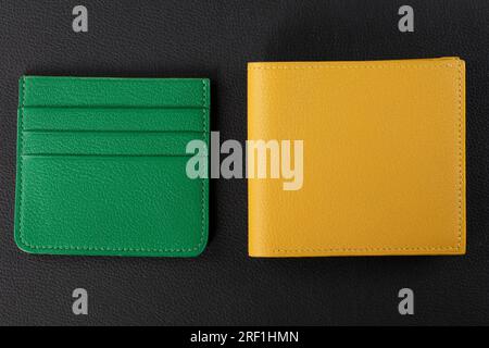 Leather products. Wallet business card holder made of green and yellow genuine leather on a black background. Stock Photo