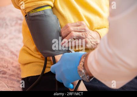 A doctor using a sphygmomanometer with a stethoscope revealed arterial hypertension in a patient in the hospital. Stock Photo