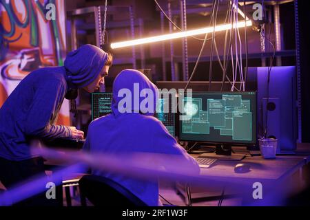 Hackers breaking website and checking malware code on multiple windows on computer screen. Criminals doing ddos attack illegal activity using malicious software and stealing data Stock Photo