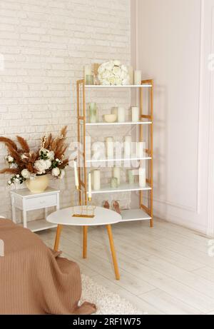 Wedding interior of room. On shelf lies a white bouquet of bride flowers, candles, glasses, table and shoes. Beautiful background. Stock Photo