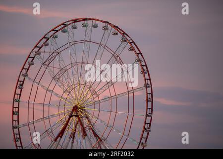 Retro ferris wheel carousel on the background of the evening sky. Stock Photo