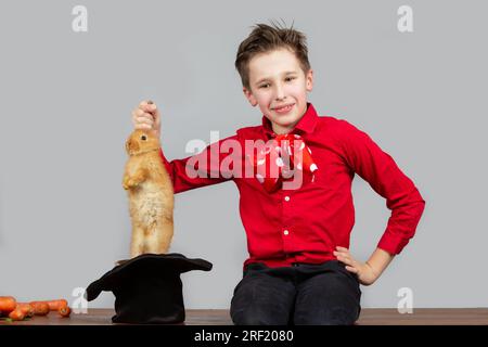 A magician boy takes a hare out of his hat. Stock Photo