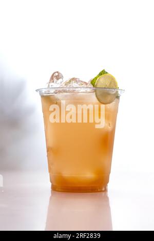 Iced peach cooler drink in plastic cup chilled. Stock Photo