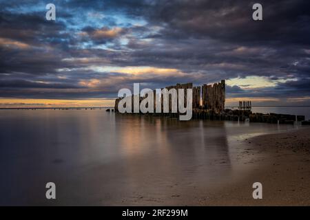 Old pier remains on the Baltic Sea, wooden posts in smooth water at dusk in Babie Doly,  Gdynia, Poland. Stock Photo