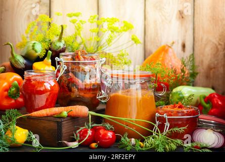 Autumn homemade preserved vegetables in glass jars - ajvar, pumpkin caviar,ratatouille,pickled carrot.  Fall preserved vegetarian food concept, copy s Stock Photo