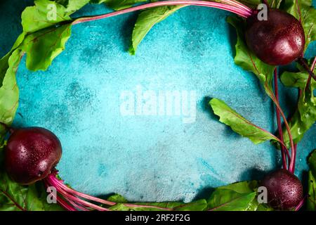 Fresh organic beetroot with green leaves on a  blue background. Top view, copy space. Stock Photo