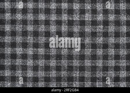 The texture of linen fabric in a large cell of black and white. Scottish tailoring material. checkered fabric Stock Photo
