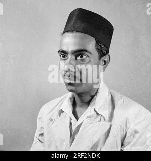 old vintage 1900s black and white studio portrait of Indian man wearing black topi cap India 1940s Stock Photo