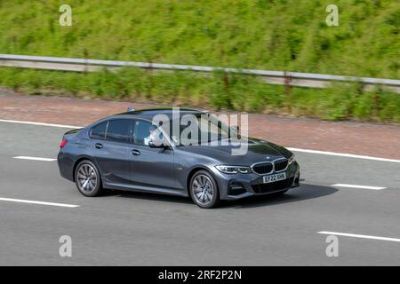 2022 BMW 330E M Sport Auto 330E 292 12Kwh PHEV 113Hp/83Kw Step Auto Start/Stop Car Saloon Hybrid Electric 1998 cc travelling at speed on the M6 motorway in Greater Manchester, UK Stock Photo