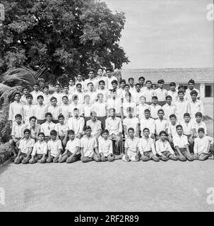 old vintage black and white 1900s picture of Indian school children teacher group photo India 1940s Stock Photo