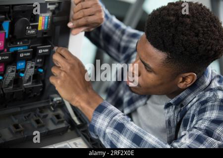technician tries to repair a printer Stock Photo