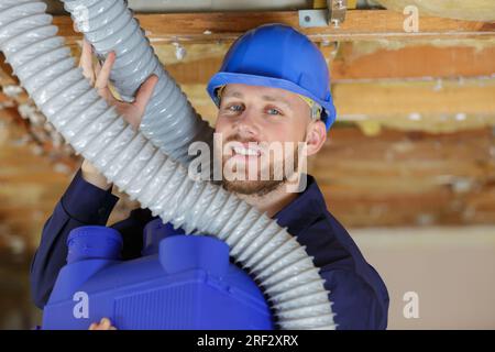 a plumber checking ceiling pipes Stock Photo