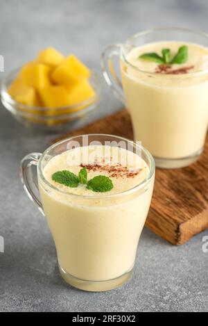 Lassi mango on a gray background. Side view, selective focus. Milkshake with mango. Stock Photo