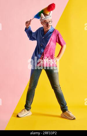Creative collage of two halves of emotional young man in various fashion style outfits expressing positive emotions Stock Photo