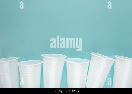 Row of plastic drinking cup on blue background. Eco concept Stock Photo