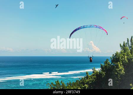 Paraglider flies in front of the blue ocean Stock Photo