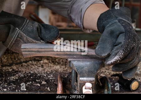 Hand craftsman uses rasp decorate to polish the handle wood hammer handle Stock Photo