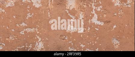 Old rough brown wall mit remnants of bright plaster Stock Photo