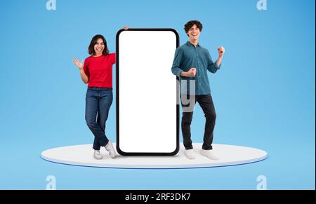 Excited arab woman and european woman standing by big phone Stock Photo