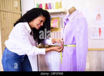 Lady Measuring New Garment on Dummy Working At Clothing Atelier Stock Photo