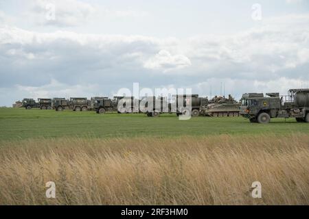 British Army Warrior FV510 fighting vehicle tank refuelling from a M.A.N. HX58 unit support tanker in action on a military exercise Stock Photo