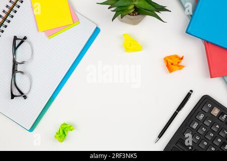 Notepads, calculator and paper reminders on a white background, top view. Stock Photo