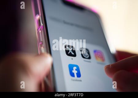Bangkok, Thailand - July 30, 2023 : iPhone 13 showing its screen with popular social media apps, which are X, Threads, Instagram and Facebook. Stock Photo