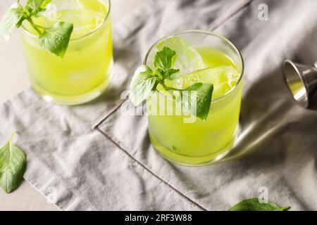 Gin Basil Smash Cocktail booze gin, lemon juice, syrup and basil leaves Stock Photo