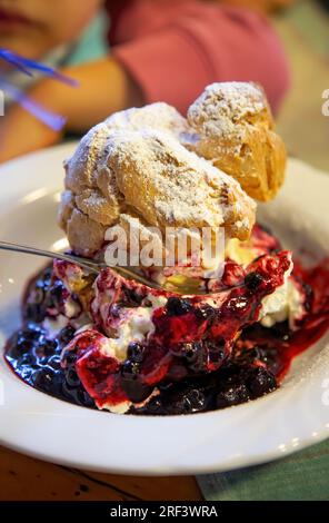 Big cream puff with hot cherries Stock Photo