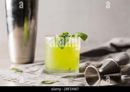 Gin Basil Smash Cocktail booze gin, lemon juice, syrup and basil leaves Stock Photo