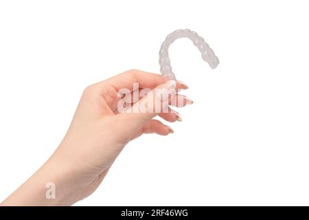 Transparent mouth guard in a woman's hand isolated on a white background. Stock Photo