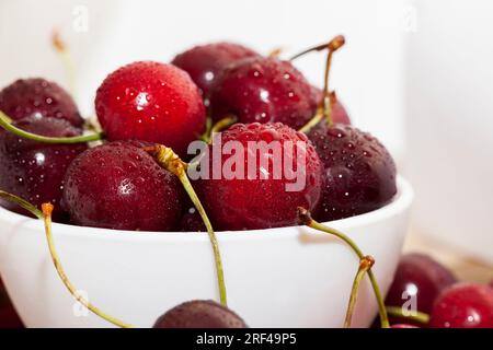 delicious sweet cherries washed and therefore covered with drops of water, fresh edible berries, berries with bones and tails Stock Photo