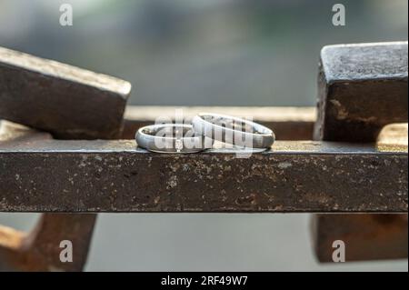 Two hands with wedding rings rest on a strong anchor chain. Stock Photo
