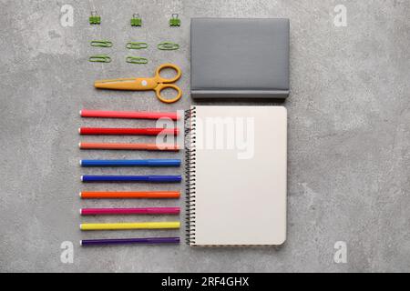 Composition with notebooks, scissors and felt-tip pens on grunge background Stock Photo