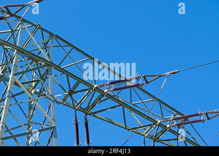 Power line pylon in front of blue sky Stock Photo