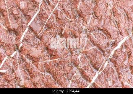 Wet stone wall. Water on a rock surface. Brown abstract background Stock Photo