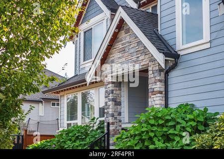 Entrance to a home through a beautiful garden with colorful flowers. Plants and flowers on a doorstep leading to entrance of a house. Front of a house Stock Photo