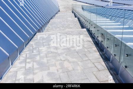 Abstract modern architecture background with new shiny roof made of stainless steel plates, handrails and stone stairway Stock Photo