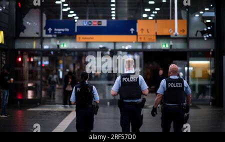 Essen, Germany. 31st July, 2023. Police officers walk through the station. After a World War II bomb was found, the rail line between Essen Central Station and Essen West was temporarily closed on Monday evening. All buildings within a 300-meter radius of the site where the unexploded bomb was found in the West district were evacuated. The bomb was defused in the evening. Credit: Fabian Strauch/dpa/Alamy Live News Stock Photo