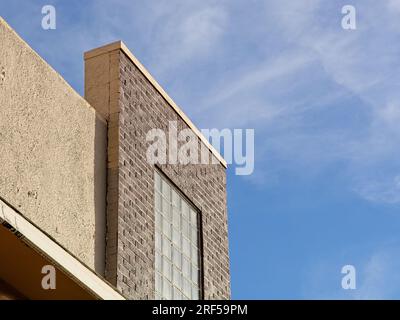 Brown brick glass block and stucco facade at roofline of commercial building in downtown Alpine Texas Stock Photo