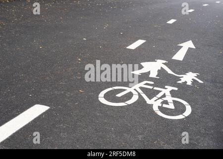 Pedestrian and Bicycle sign painted on asphalt the road surface. Shared bike lanes  in Europe. Public park Stock Photo