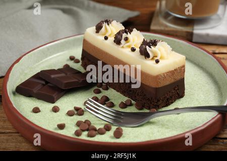 Tasty mousse cake, chocolate and fork on plate, closeup Stock Photo
