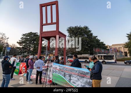 Geneva, Switzerland - 25 March 2022: Group of Bangladeshi people protesting at the Broken Chair monumental sculpture in front of the UN office in Gene Stock Photo