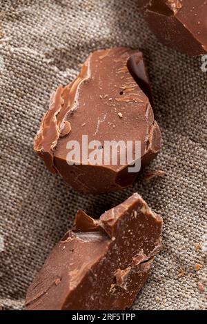 broken into several parts pieces of chocolate from cocoa, natural food from cocoa, sugar, cocoa butter, pieces of large natural real chocolate Stock Photo