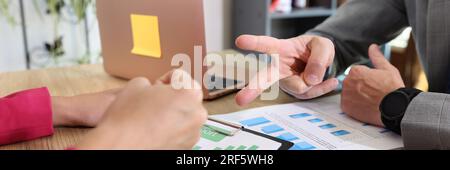 Businessman and businesswoman playing game rock paper scissors when discussing details of agreement. Stock Photo