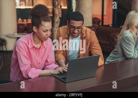 Friendly diverse business people laughing working on project together in modern coworking Stock Photo