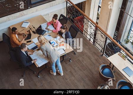 Diverse corporate team working together in meeting room. Colleagues collaborating on new project Stock Photo