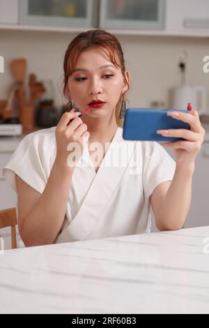 Applying makeup, transgender transgender woman using compact mirror and ...